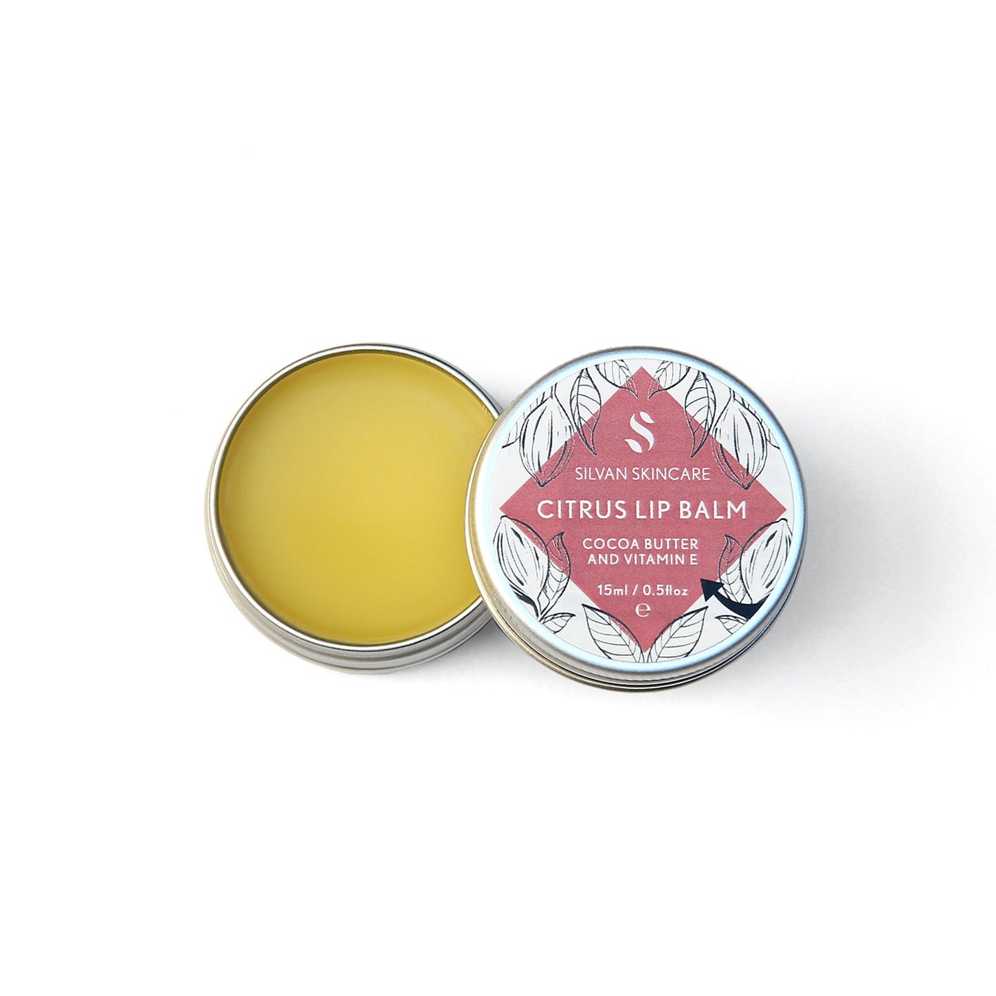 Single aluminium tin of the Silvan Skincare citrus lip balm. The pot in open, showing the yellow balm inside and the lid is beside it showing the white and pink label