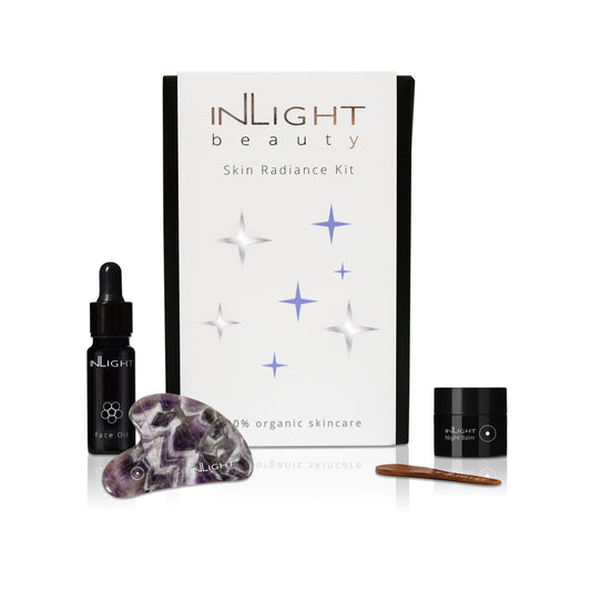 gift set of products from inlight beauty organic face oil, night balm and amethyst purple gua sha in a black envelope box with white sleeve with stars on it