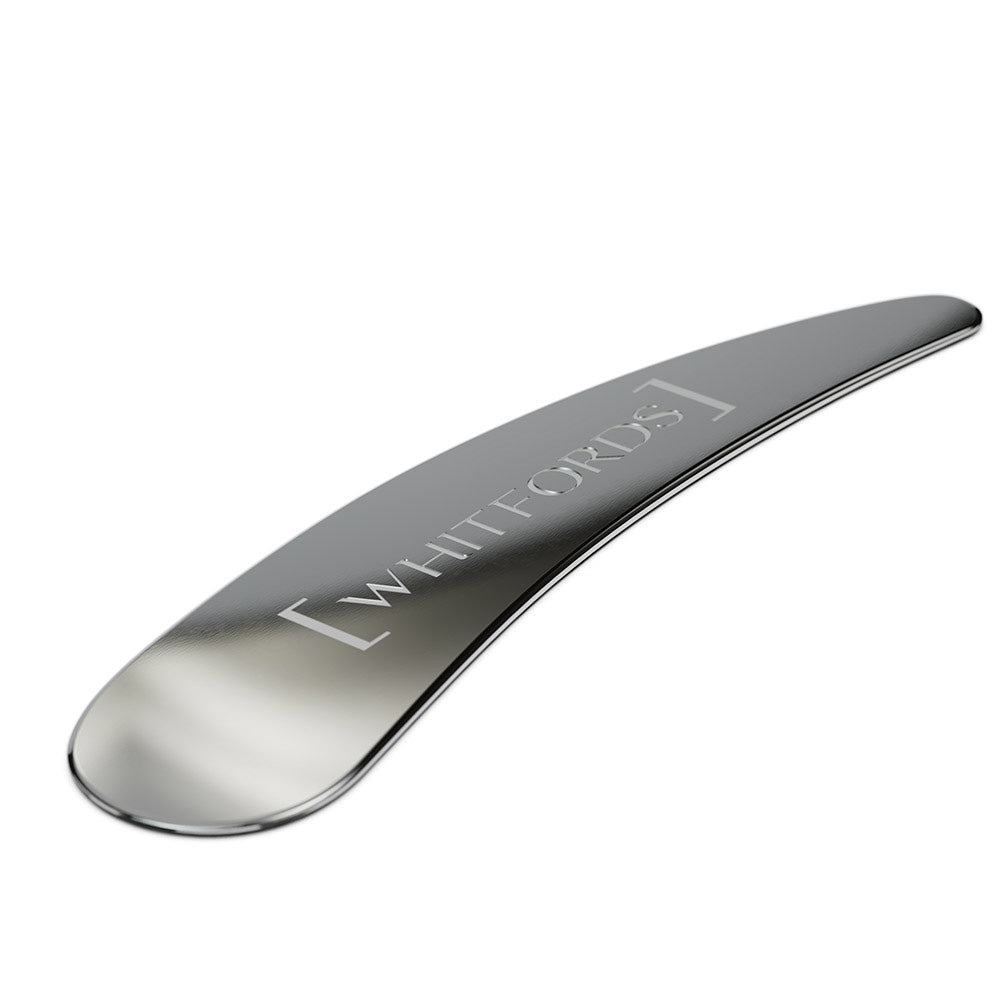 Metal skincare spatula on white background
