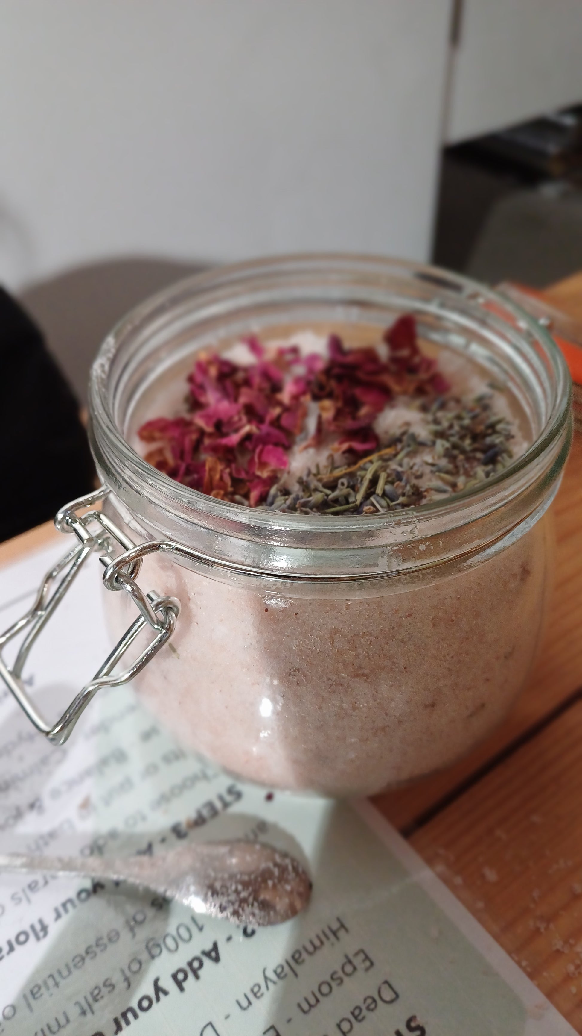 clear kilner jar of bath salts with dried rose and lavender petals on the top