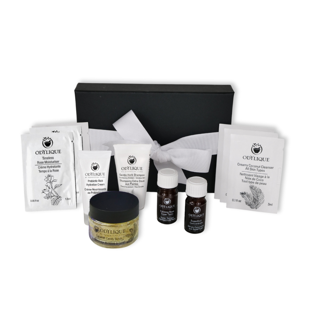 odylique organic skincare best sellers discovery gift set in a black box with white ribbon. small sachets of products to try as well as travel sized miniature tubes, jars and bottles