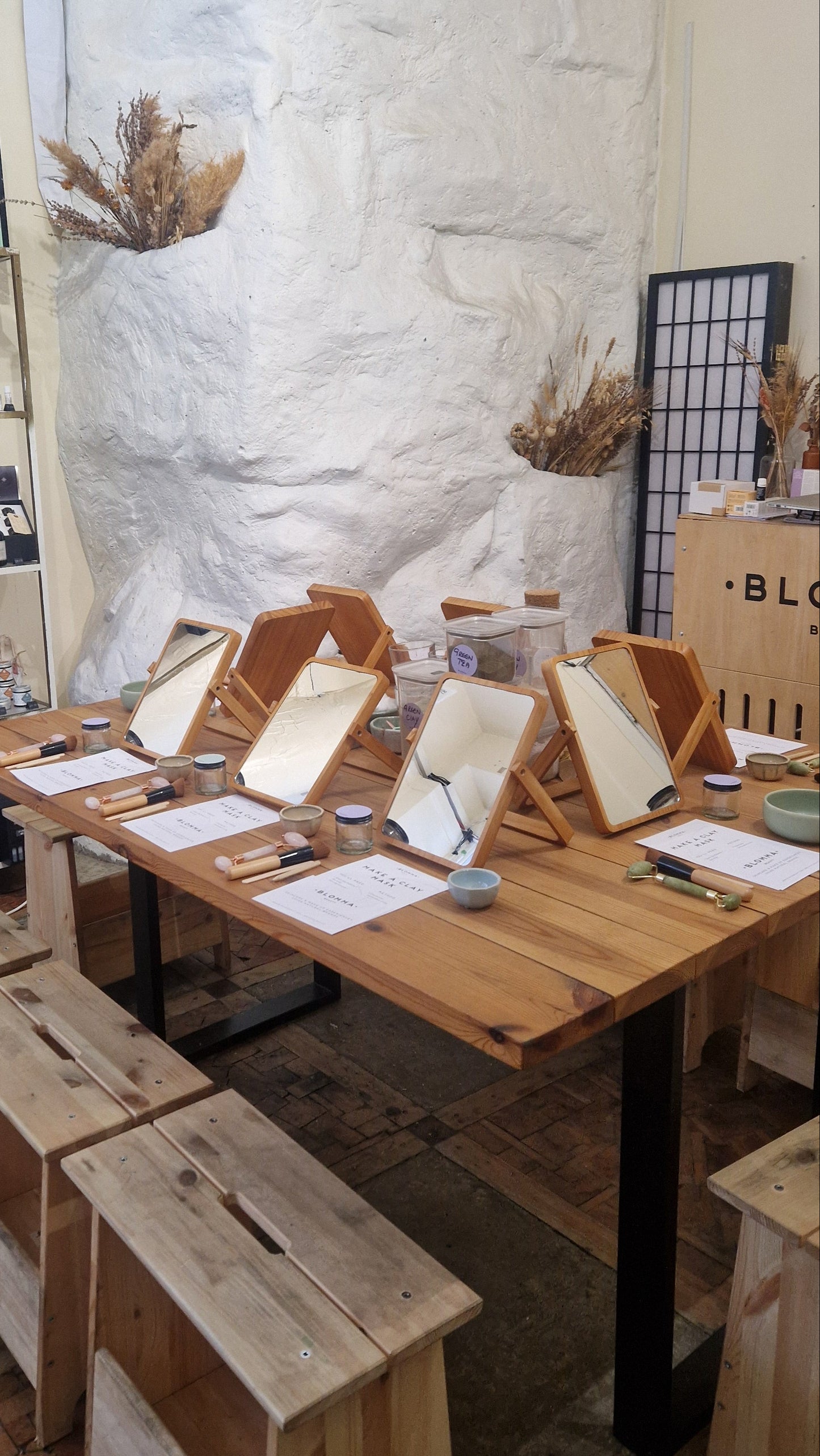 wooden table dressed with mirrors, worksheets and natural skincare