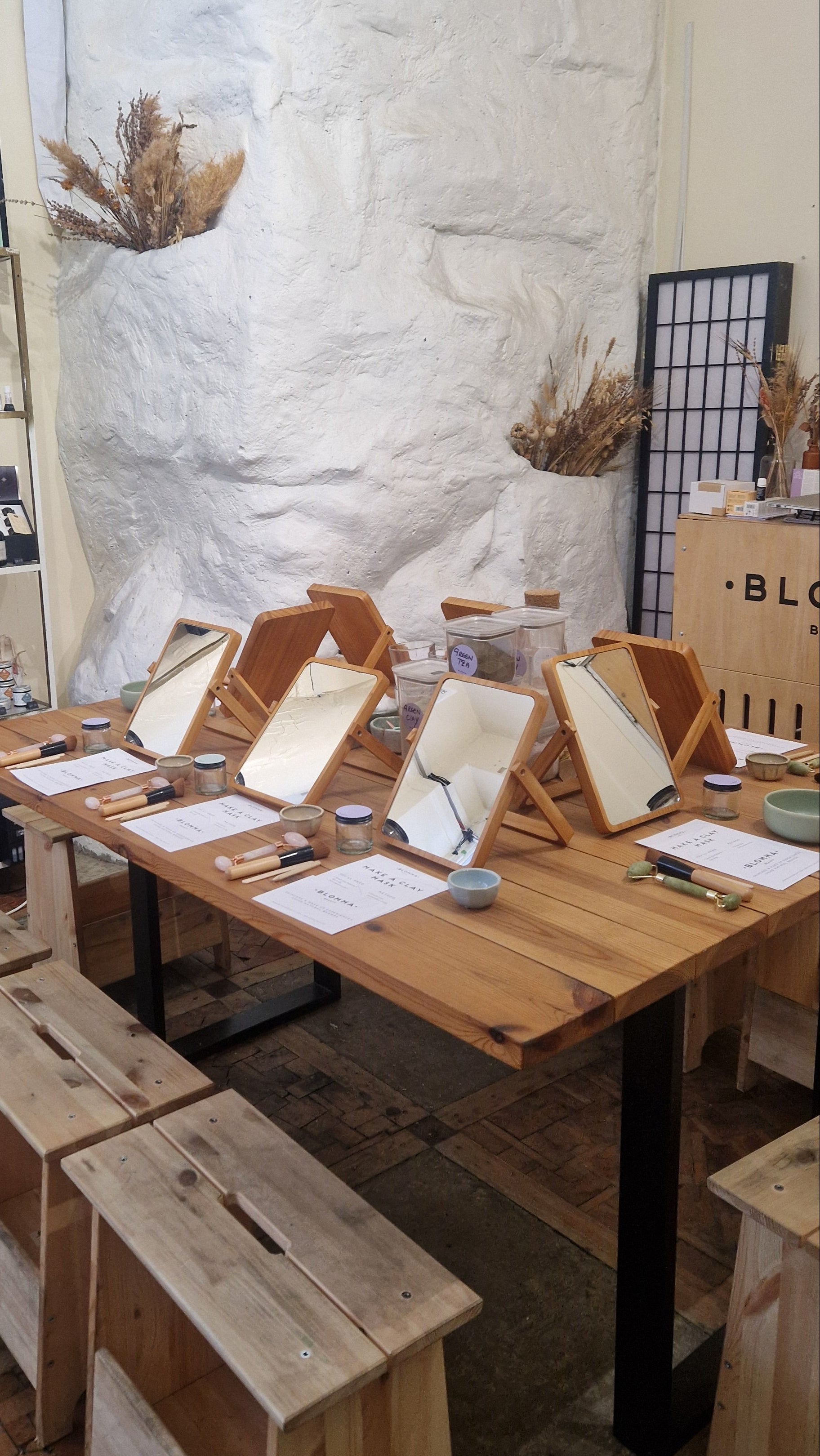 wooden table dressed with mirrors, worksheets and natural skincare
