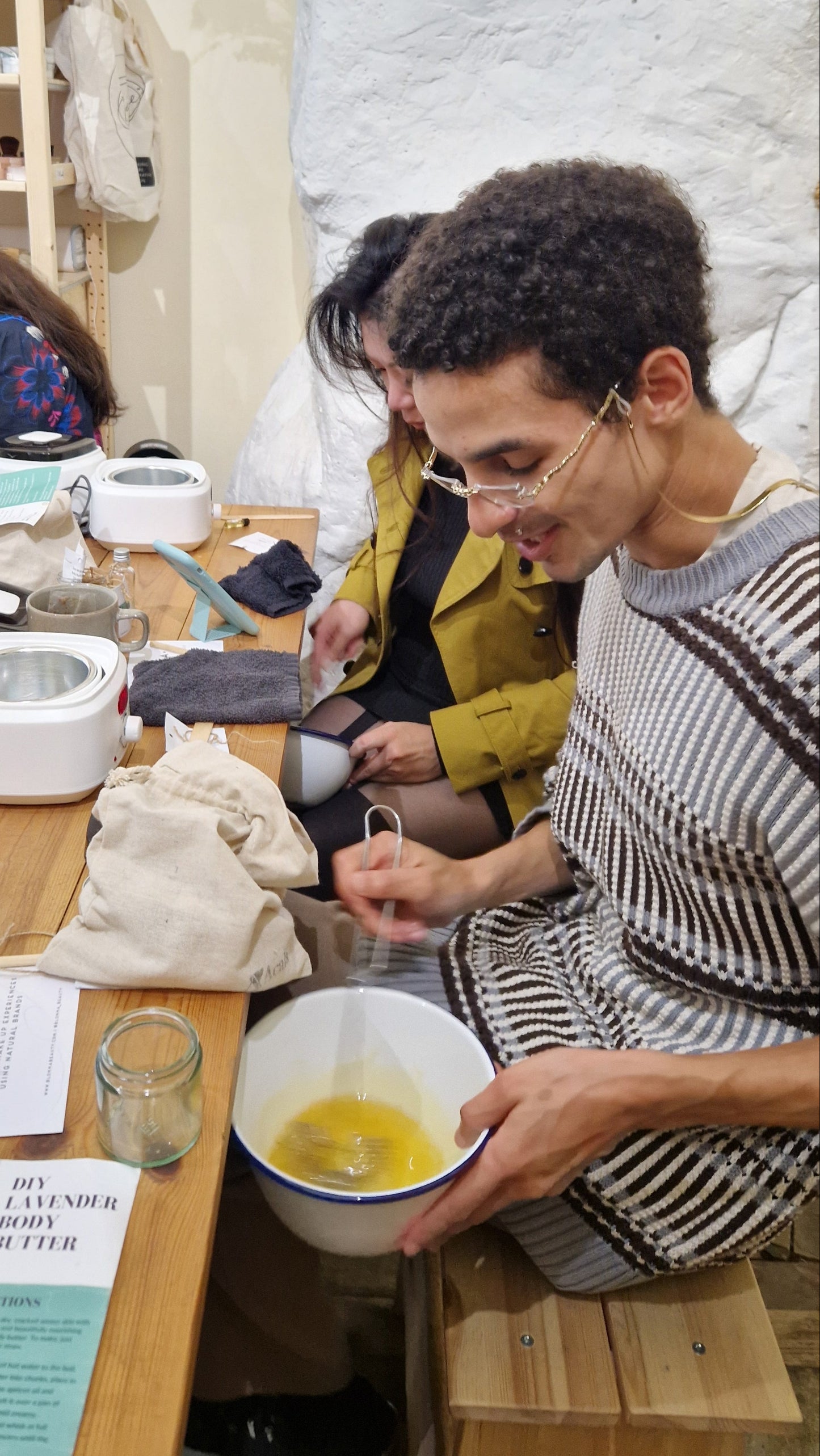 group of people whipping melted oils and butters to create a handmade body butter
