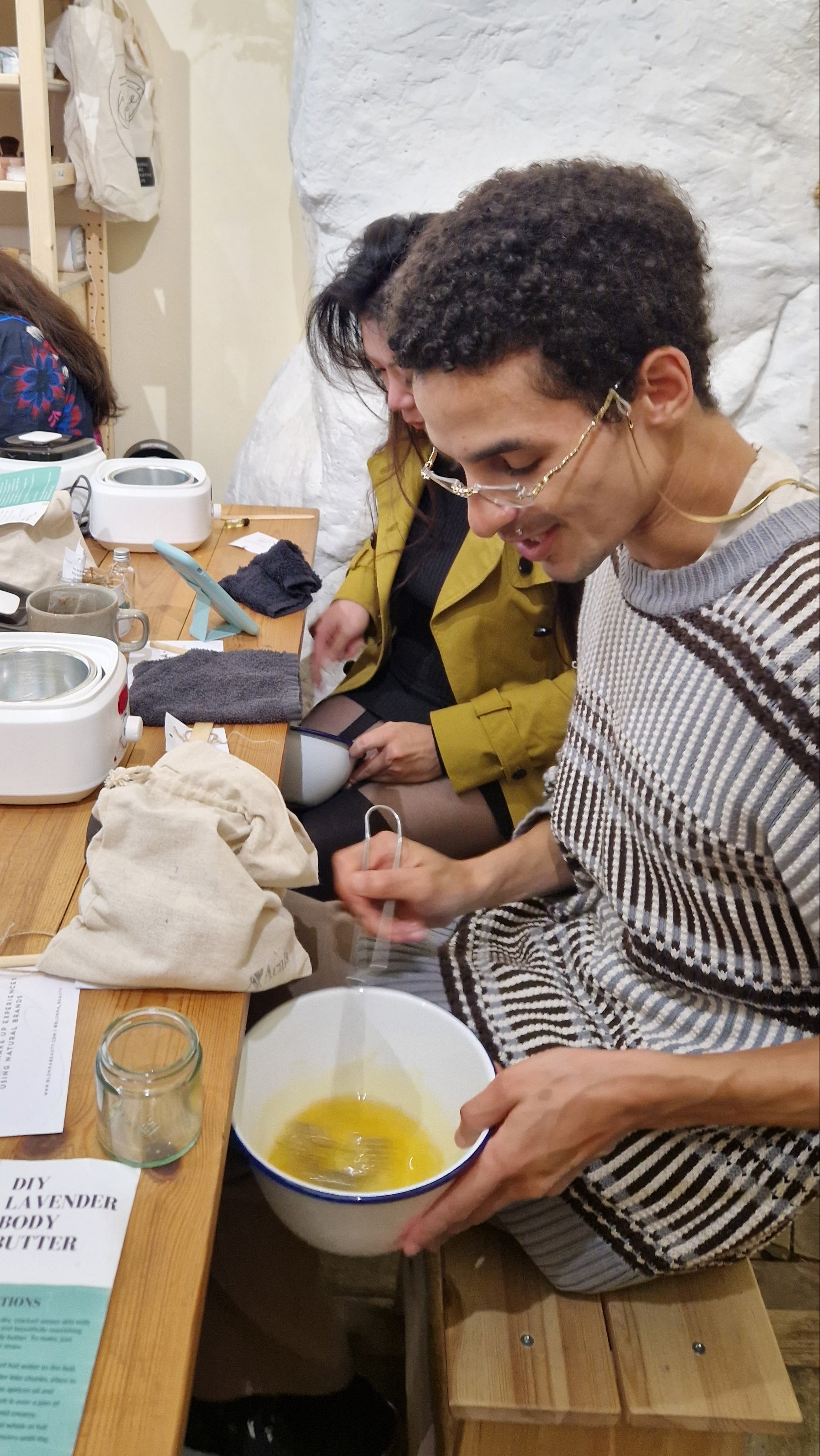 group of people whipping melted oils and butters to create a handmade body butter