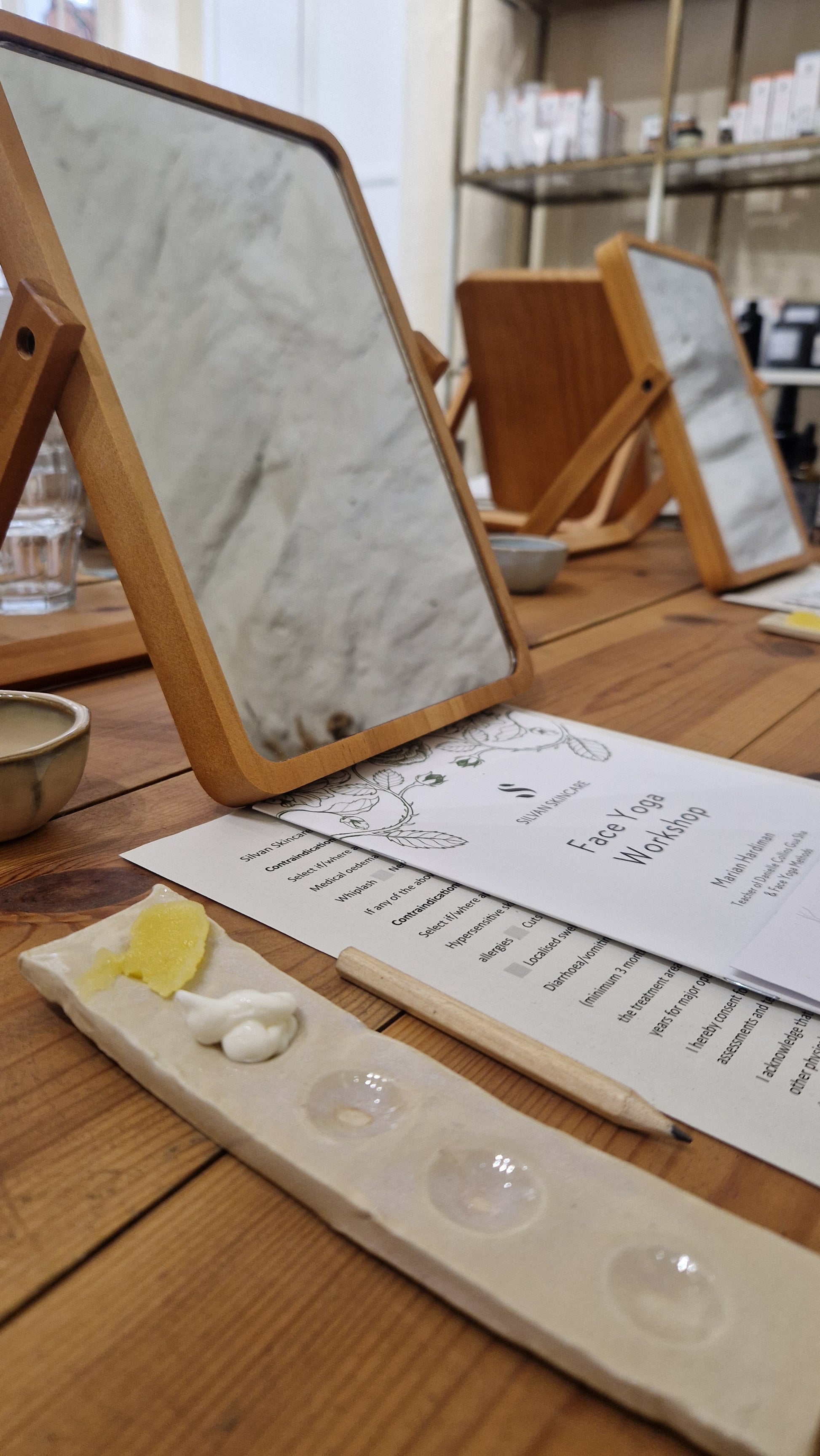 mirrors, skincare and face yoga instruction card on a wooden table