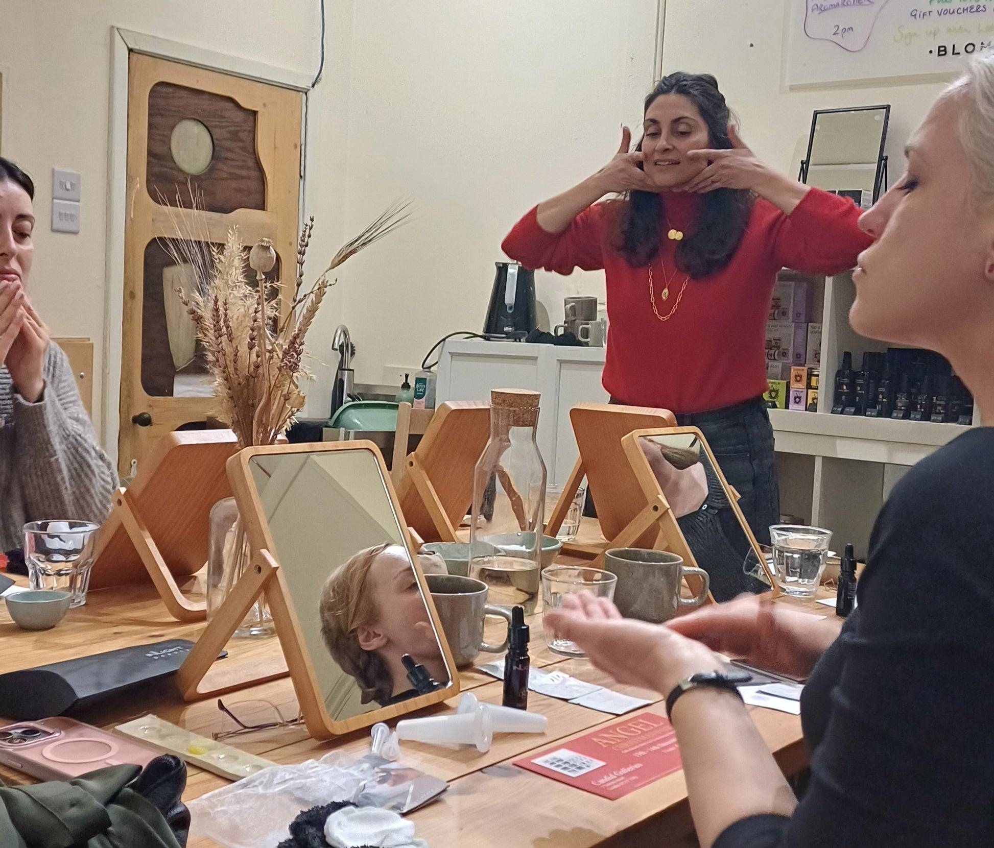 People in a room with mirrors and beauty products, in a beauty workshop about facial cupping