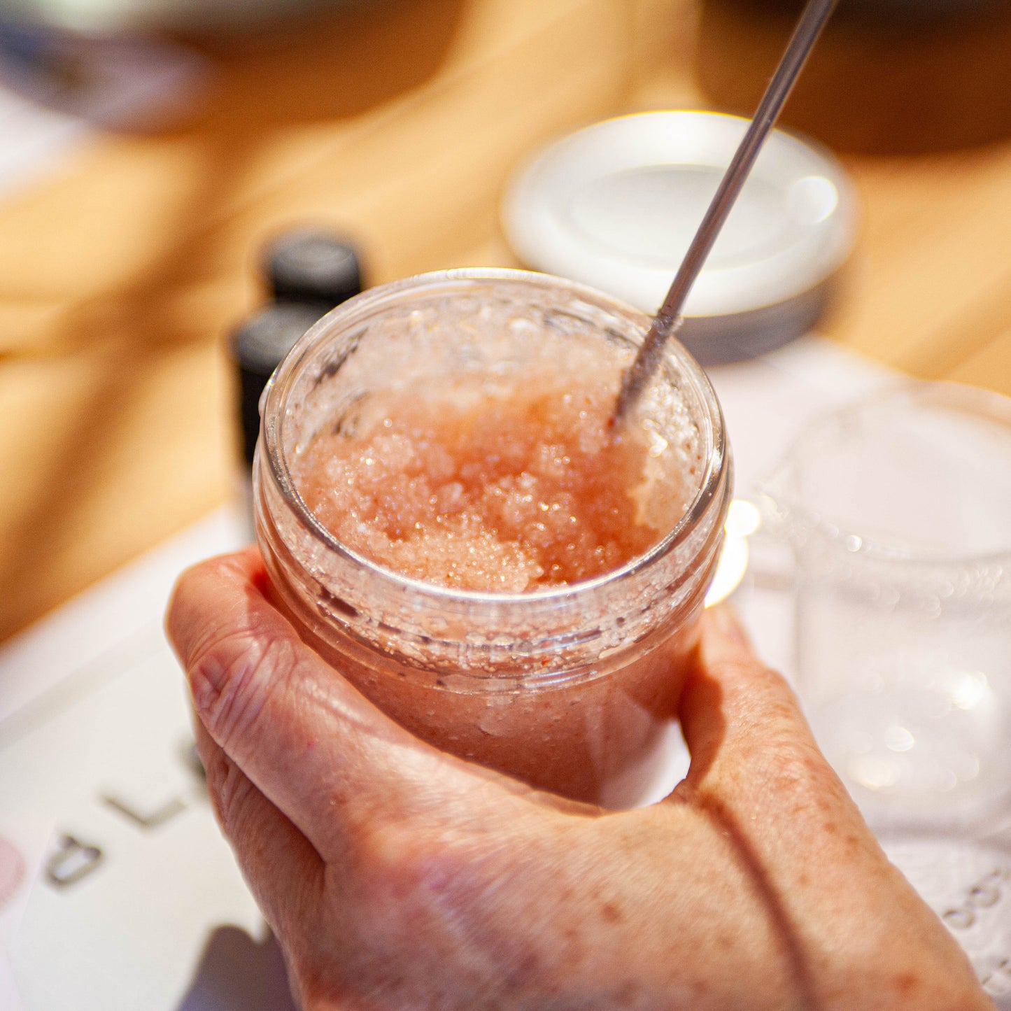 jar of body scrub being stirred