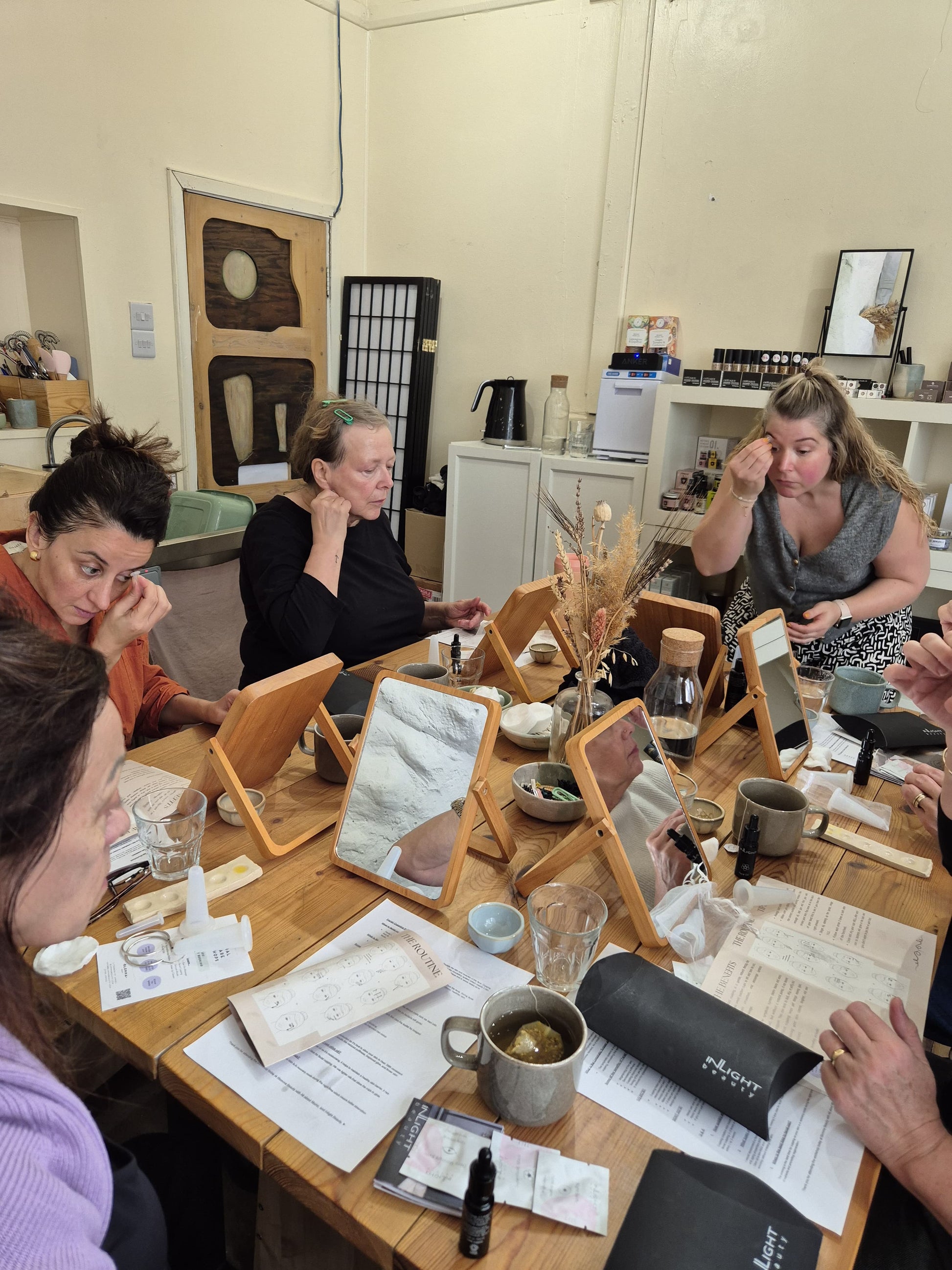 group of people following a teacher who is showing how to use silicone facial cups