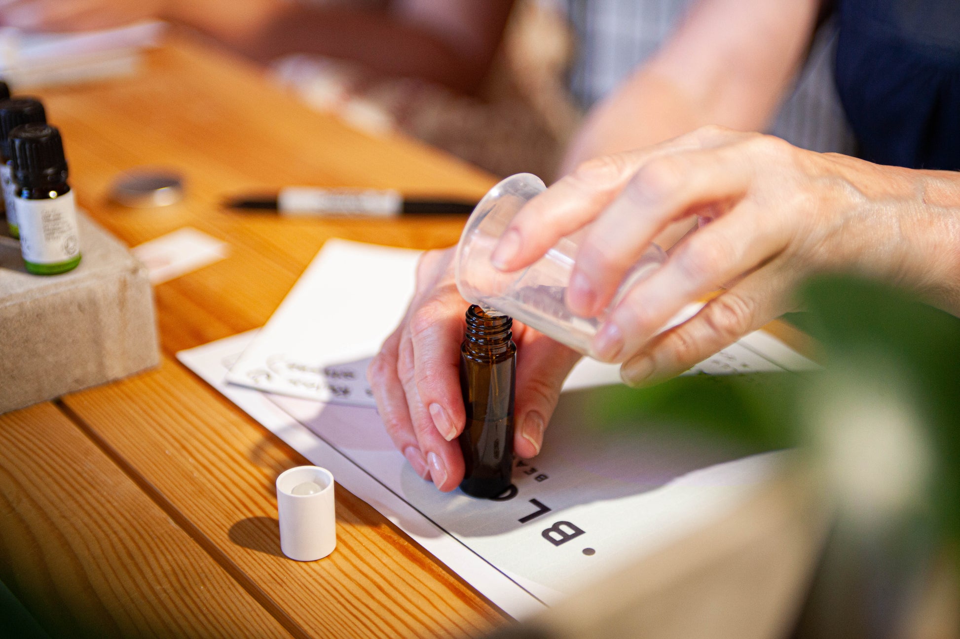 pouring essential oils in to a brown glass aromatherapy oil bottle 