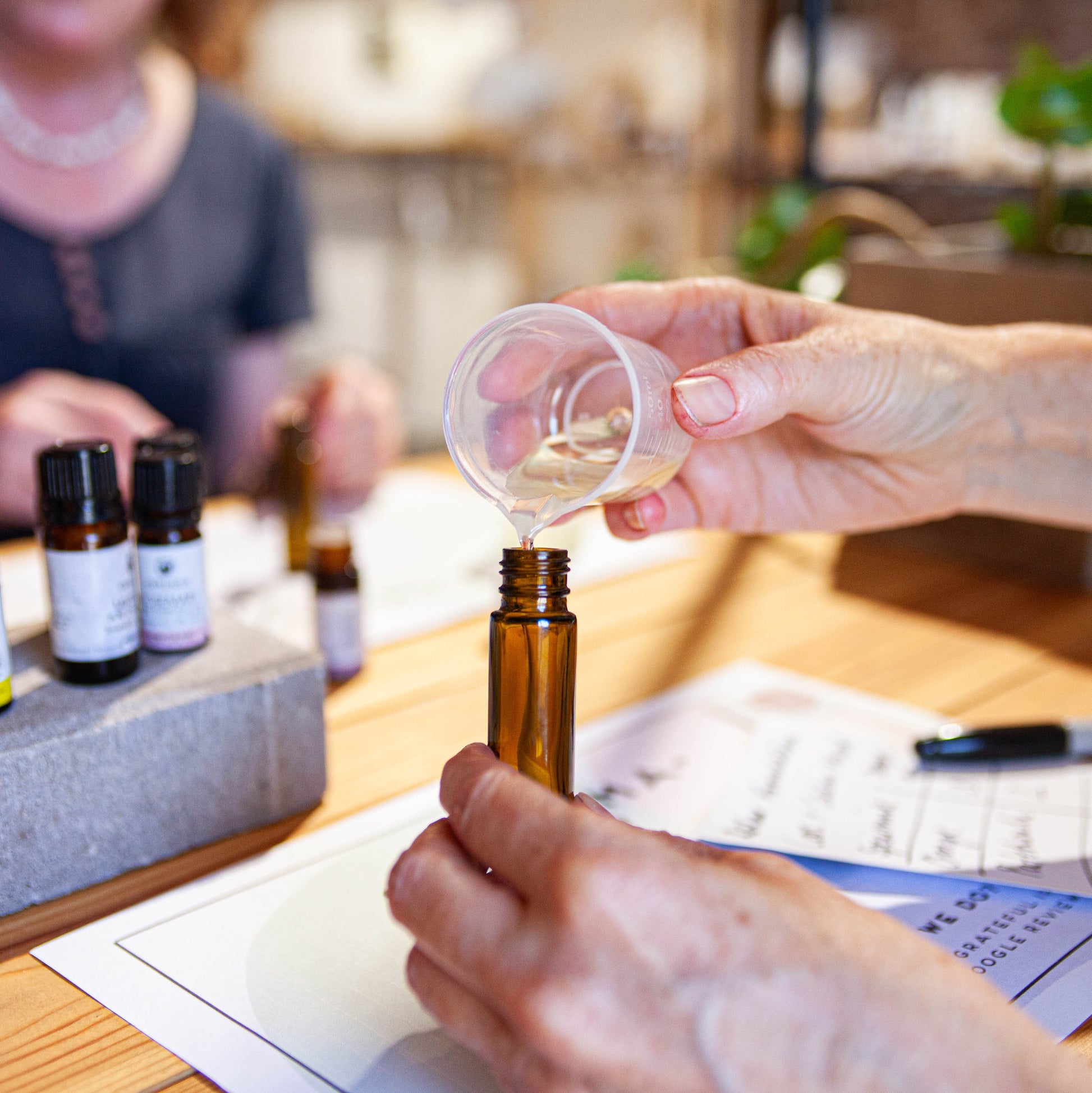 pouring a blend of oils and essential oils in to an aromatherapy roller ball