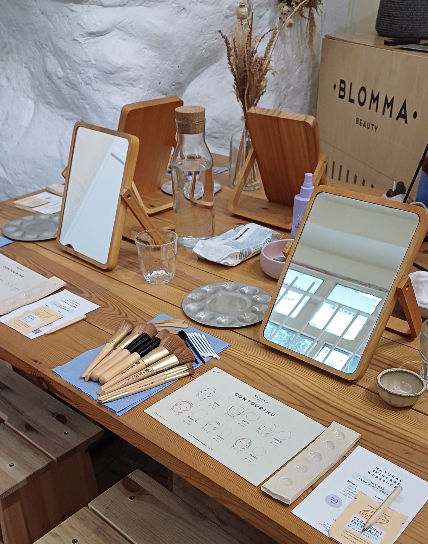 wooden table with mirror, make up brushes and worksheets ready for the natural makeup masterclass at blomma beauty