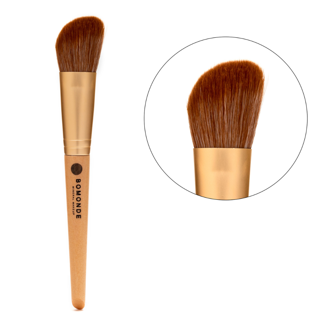 image of a bamboo handled synthetic bristled make up brush. the make up brush is angled and is stamped with the brand bomonde mineral make up in black. to the right there is a close up of the bristles encased in gold metal inside a circle