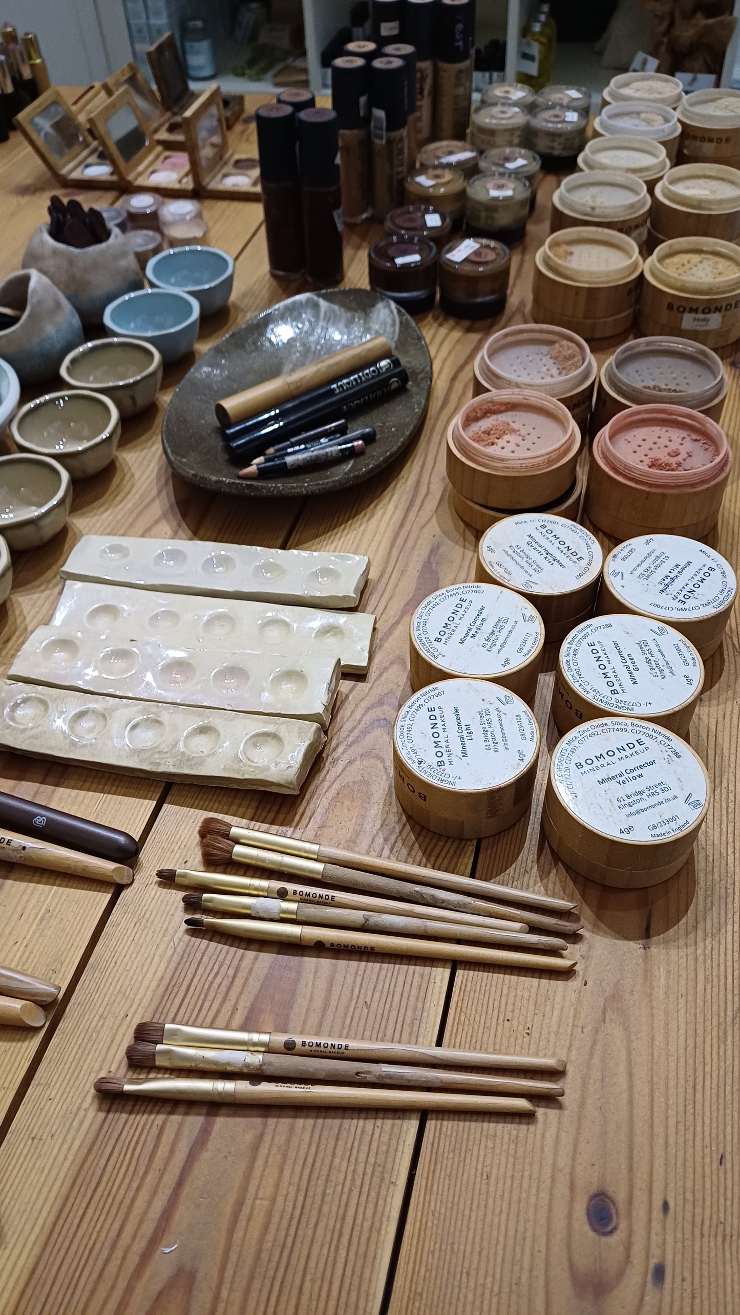 collection of makeup from different natural makeup brands on the table in blomma beauty's natural makeup studio in london