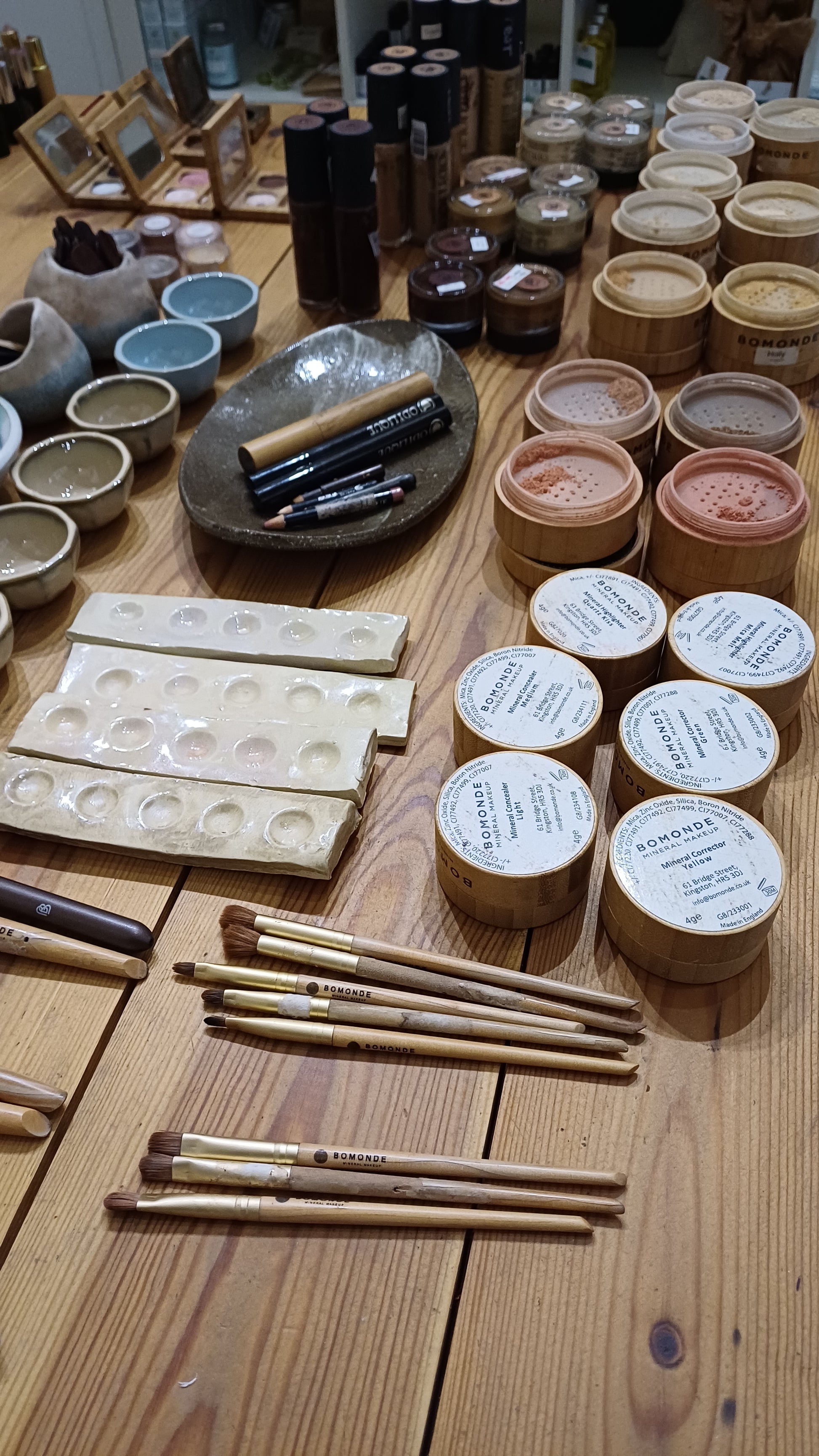 collection of makeup from different natural makeup brands on the table in blomma beauty's natural makeup studio in london
