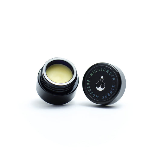 solid perfume made in the uk in a glass jar with lid showing perfume balm inside on white background