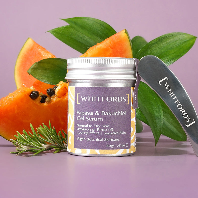 whitfords skincare papaya and bakuchiol gel serum overnight mask in an aluminium tin with a matt lilac label on a lilac background with pictures of a stainless steel spatula, dark green waxy leaves, two thin slices of papaya fruit and a frond of rosemary.. the label reads 'whitfords papaya and bakuchiol gel serum normal to dry skin, leave-on or rinse-off, cooling effect, sensitive skin. vegan botanical skincare'