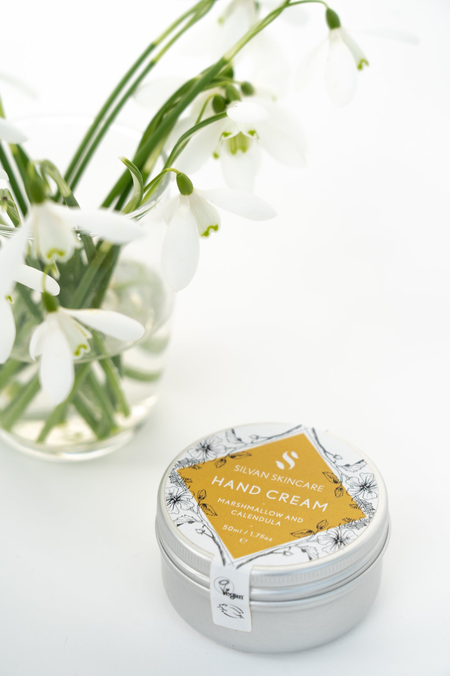 silvan skincare hand cream on a white background. the hand cream is in an aluminium pot with a white and yellow labels which reads: silvan skincare hand cream marshmallow and calendula 50ml