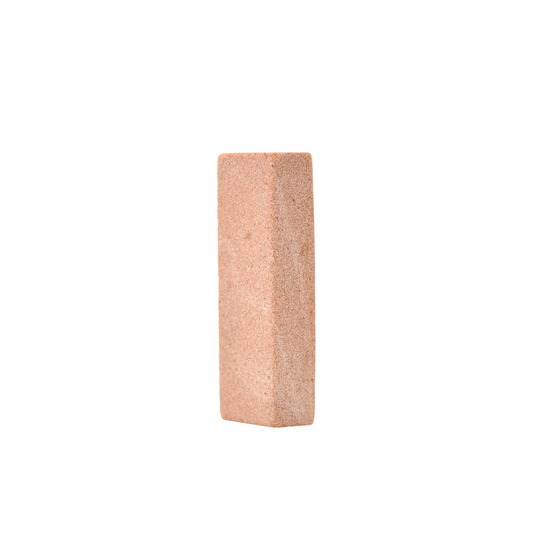 A pink oblong stone on a white background is the Acala Natural nail file handmade in Sweden from upcycled sandstone.