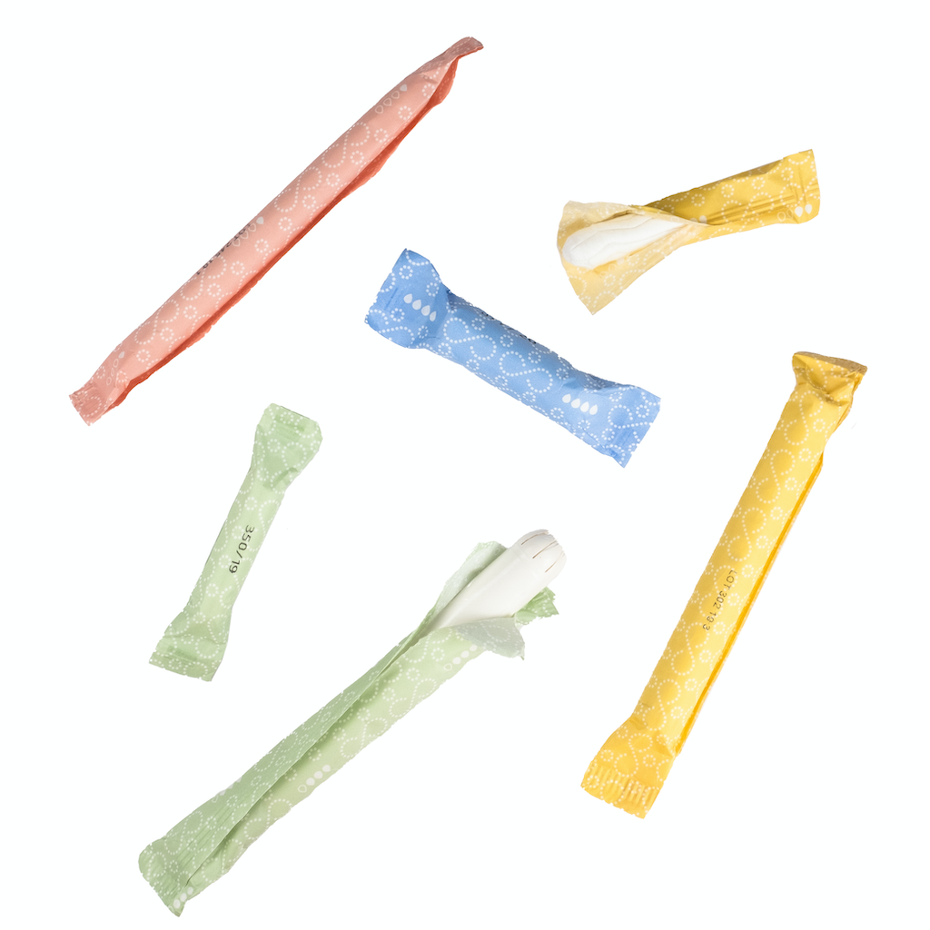 &Sisters Organic Eco Applicator Tampons. Organic Cotton Tampons. A selection of loose paper wrapped tampons against a white background.