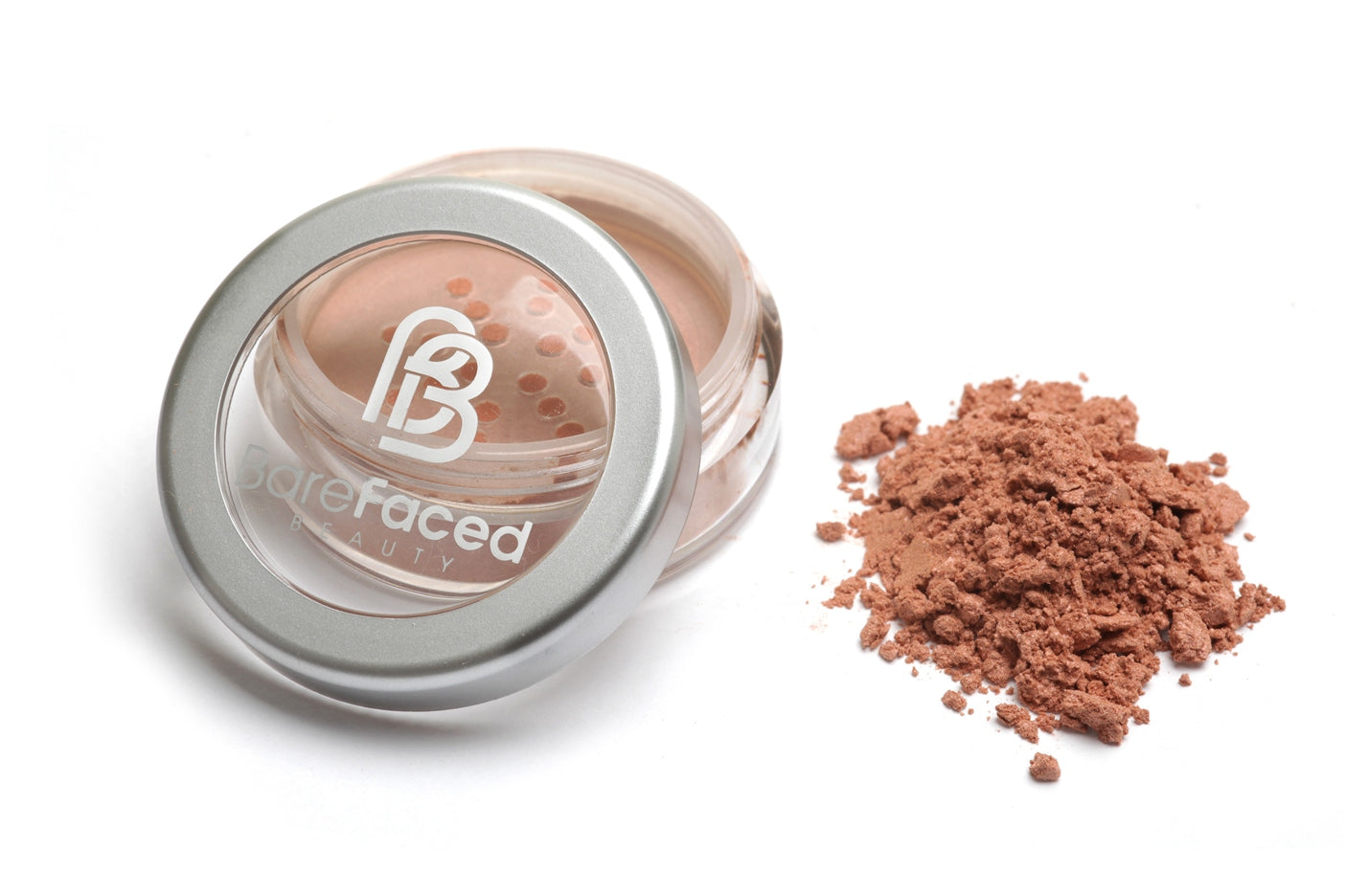 A small round pot of mineral blusher, with a swatch of the powder next to it showing a subtle satin, apricot shade