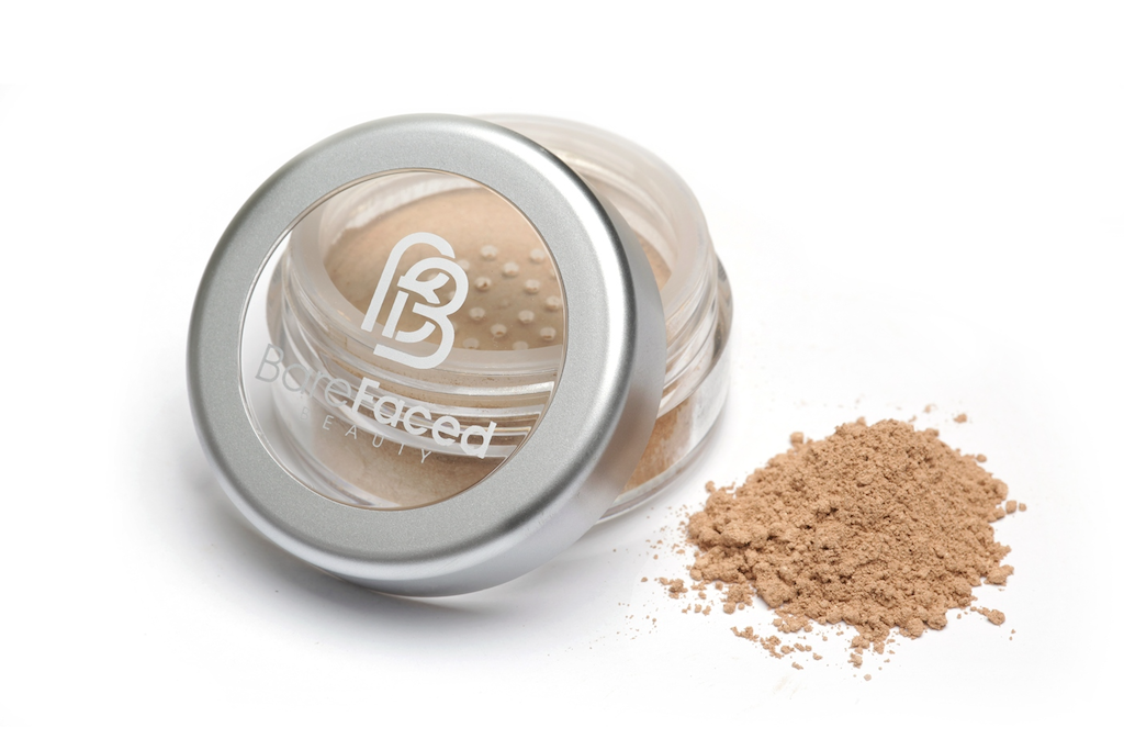 BareFaced Beauty Natural Mineral Foundation in Charmed. Ethical mineral makeup. The powder mineral foundation is pictured in a clear plastic jar with a small pile of the powder sitting next to it.