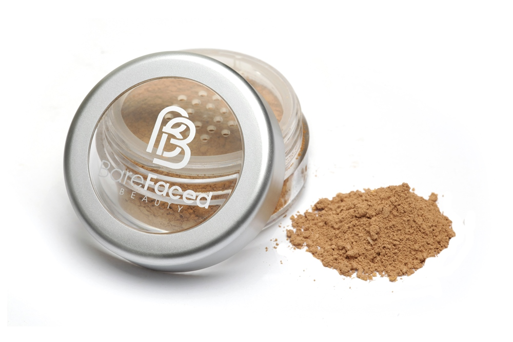 BareFaced Beauty Natural Mineral Foundation in Precious. Ethical mineral makeup. The powder mineral foundation is pictured in a clear plastic jar with a small pile of the powder sitting next to it.