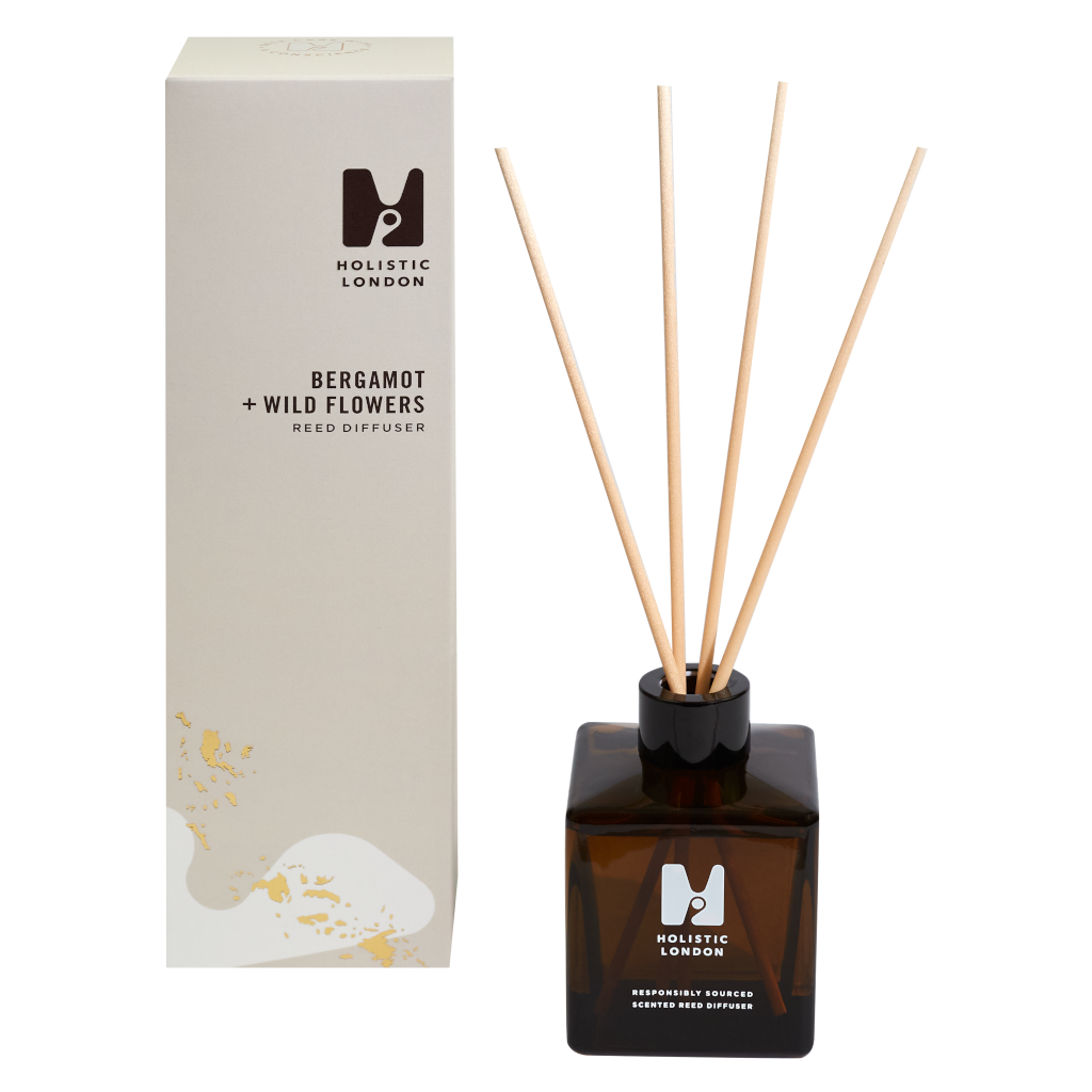 photo of a taupe tall box sitting next to a reed diffuser made from brown glass and with 4 wooden reeds inside. the scent of the diffuser is bergamot and wild flowers