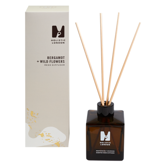 photo of a taupe tall box sitting next to a reed diffuser made from brown glass and with 4 wooden reeds inside. the scent of the diffuser is bergamot and wild flowers