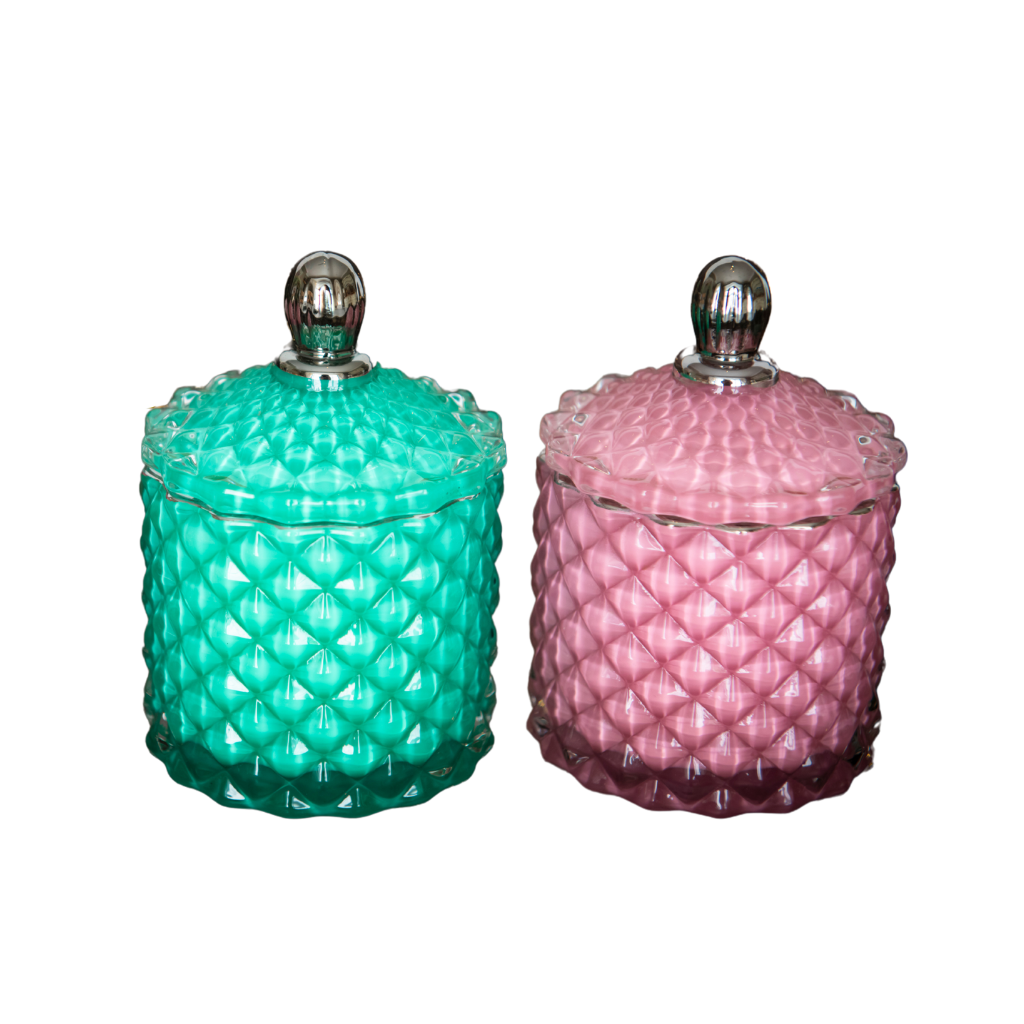 Bowe organics candle, pictured on a white background are two soy candles. On the left in a green textured glass, with a green textured glass lid and a silver handle and on the right a pink textured glass, with a pink textured glass lid and a silver handle 