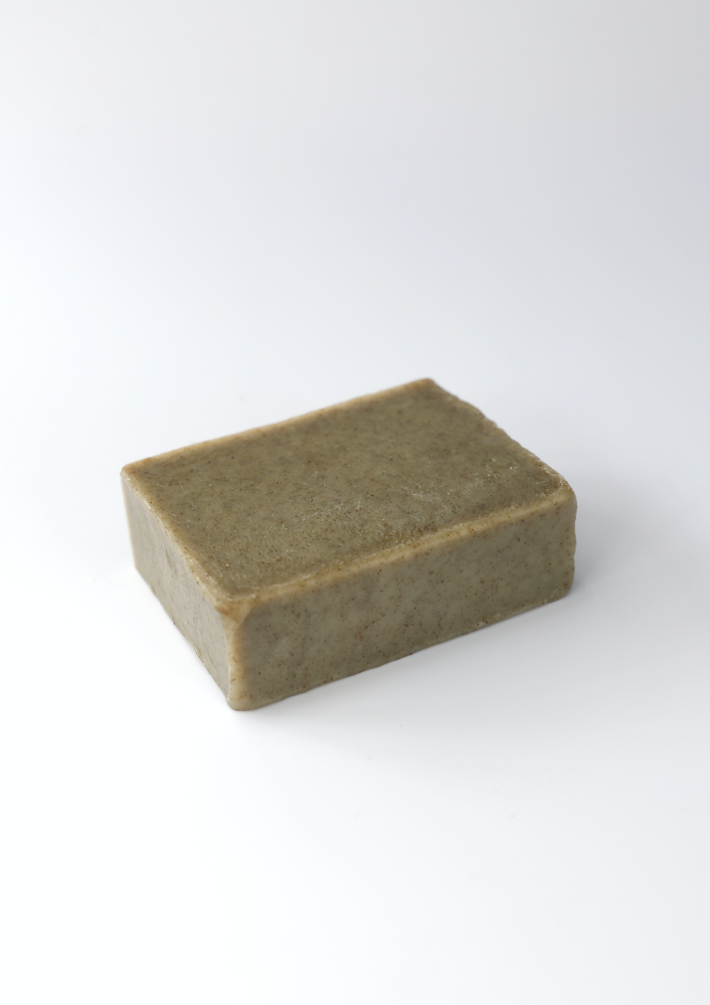 Coraline Skincare Nettle Settle Soap. Organic soap. The dark green soap bar is pictured alone on a plain white background.