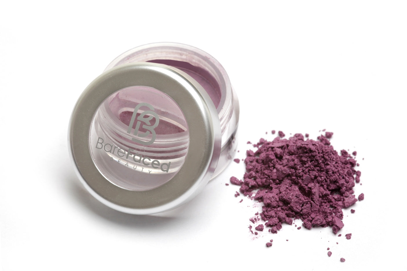 A small round pot of mineral eyeshadow, with a swatch of the powder next to it showing a Deep purple with a slight shimmer