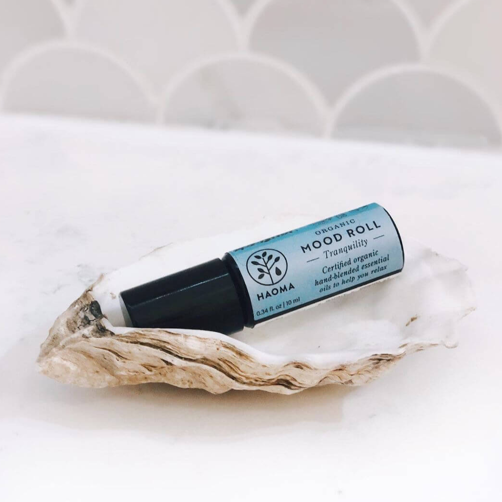 Haoma Aromatherapy Mood Rollers. Certified vegan aromatherapy for anxiety. The Tranquility mood roller is sitting in an empty oyster shell.