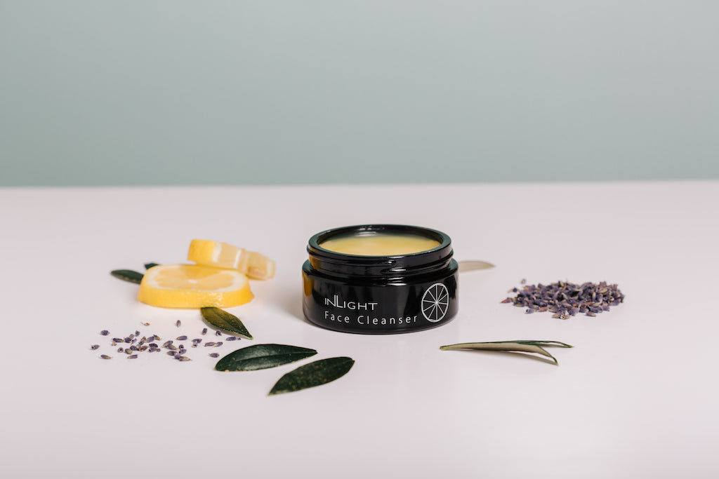inlight beauty's 100% organic cleansing balm made in cornwall with only natural ingredients can be seen sitting alongside some of the ingredients within the product which include bay, dried lavender and lemon