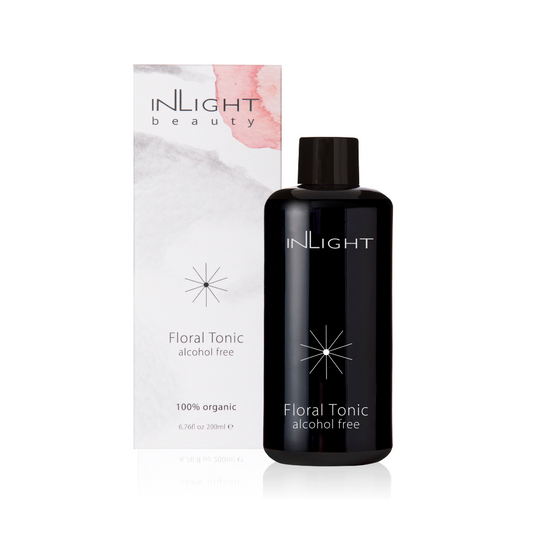 inlight beauty 100% organic floral tonic on a white background. in the background is the white, light grey and pink splashed design cardboard box and in the foreground is the black miron glass bottle for the face toner. the bottle and box reads 'inlight floral tonic alcohol free'