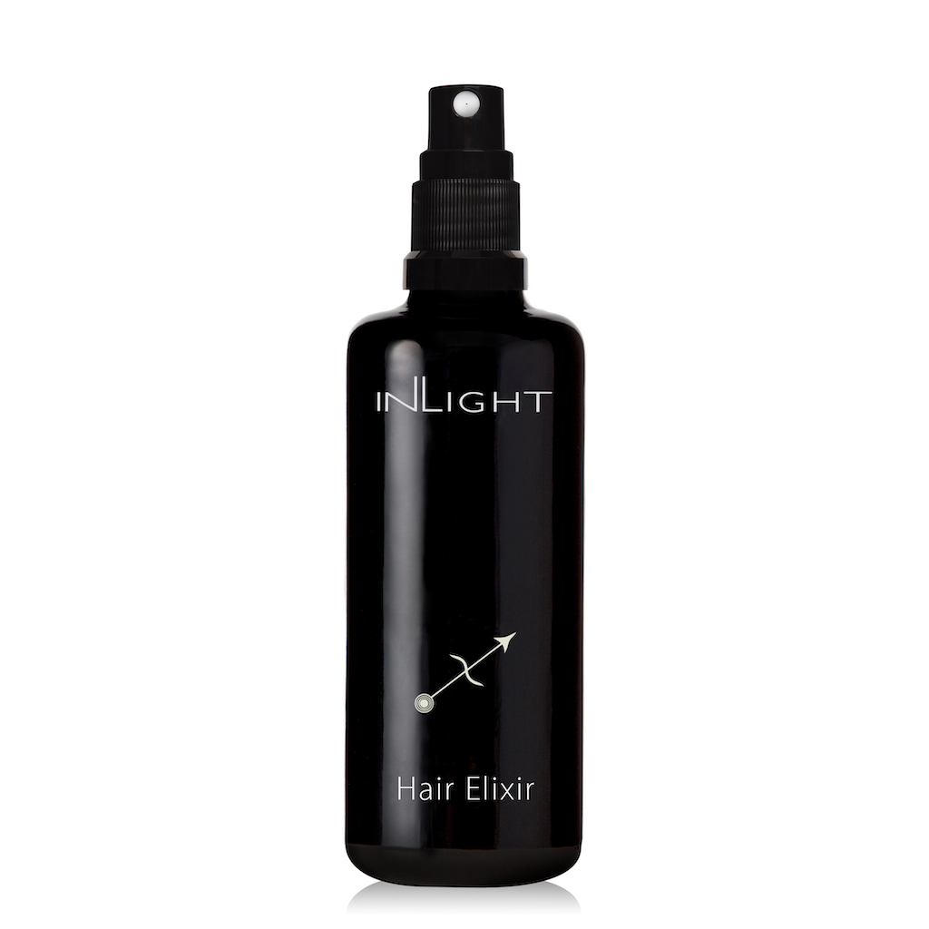 photo of a black miron glass pump bottle which contains inlight beauty's organic hair oil on a white background