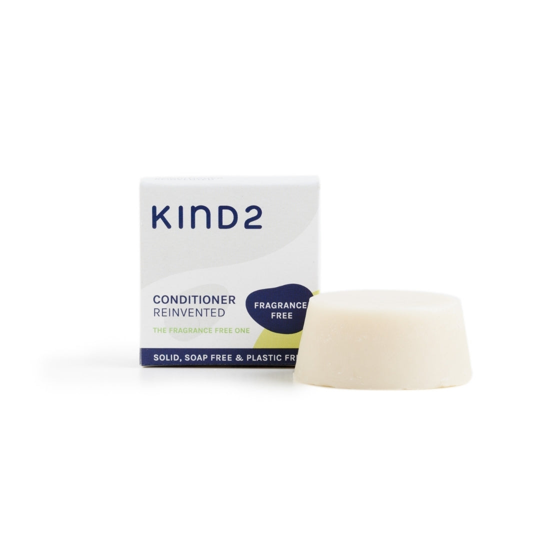 Small discovery size KIND2 conditioner bar. Placed next to the small, square grey and white box it comes in.
