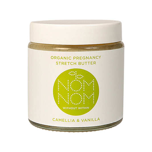 Nom Nom Organic pregnancy stretch butter on a white background. the product comes in a clear glass jar with white plastic lid and white label with green accents with Nom Nom name and logo.  