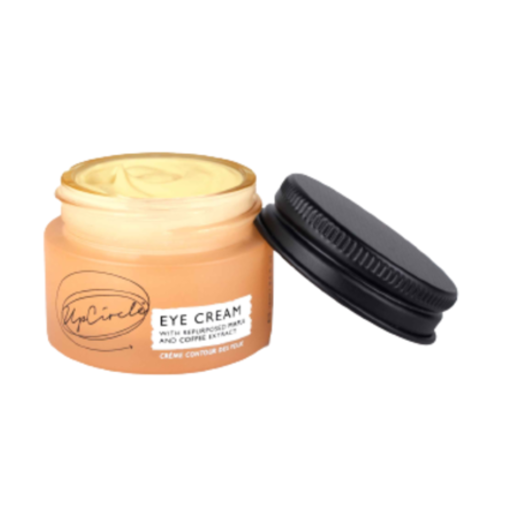 UpCircle Eye Cream. Vegan eye cream. The orange glass jar is sitting open with the black metal lid next to it.