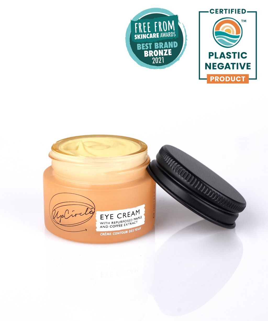 UpCircle Eye Cream. Natural eye cream. The orange jar with product is pictured open. A Free From Bronze award and a badge certifying the product as plastic negative are photo collaged on the image.