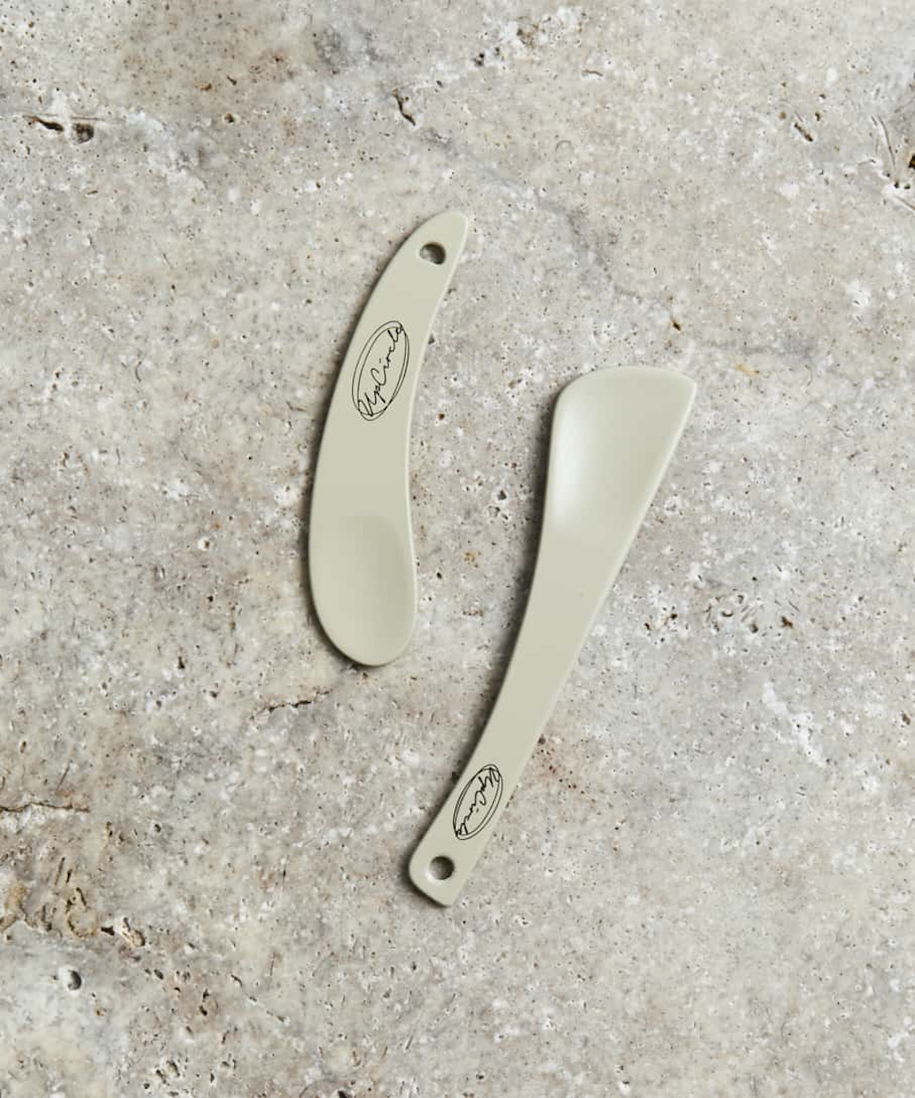 Upcircle Cosmetic Spatulas. Recyclable beauty accessories. The spatulas are pictured on a concrete surface.