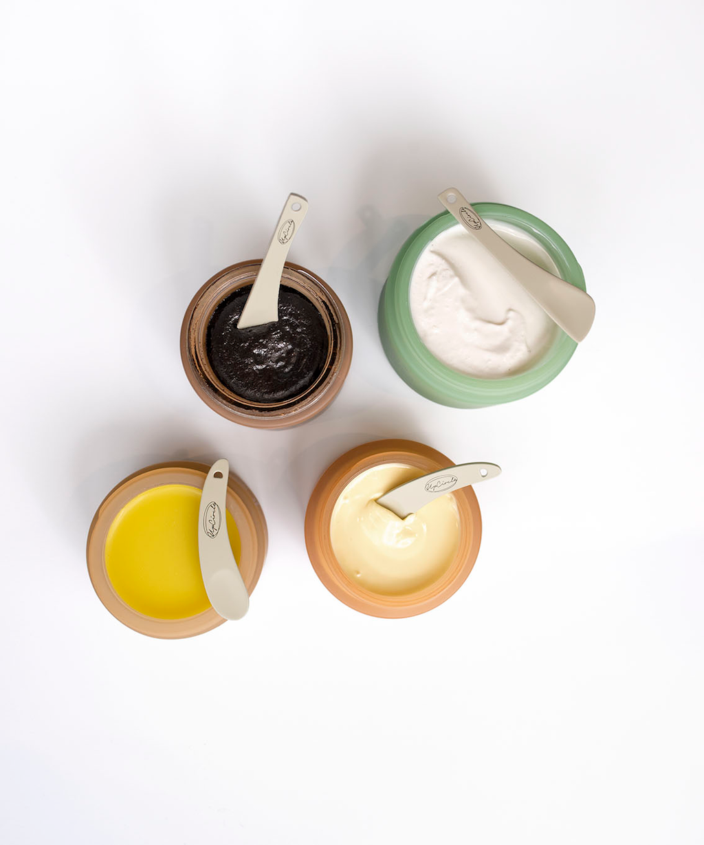 Upcircle Cosmetic Spatulas. Plastic free skincare. Four pots of Upcircle products are pictured open from the top with spatulas in or on top of them.