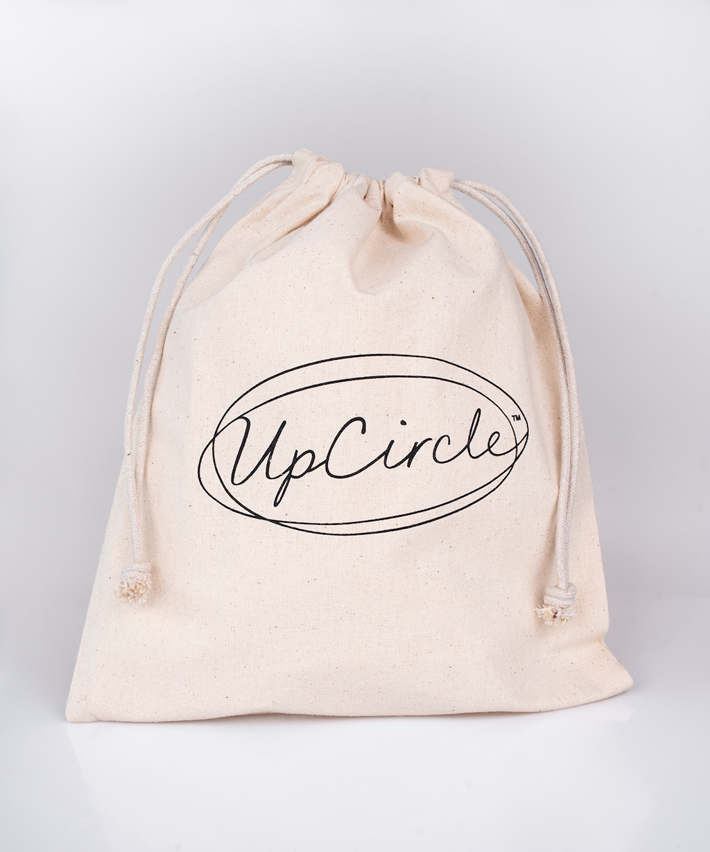 white linen bag with a drawstring which features the upcircle logo in a scrolling black font. 