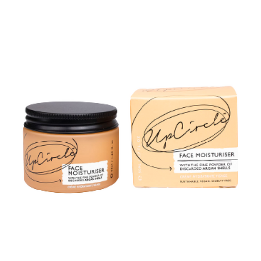 upcircle beauty face moisturiser can be seen in an orange glass jar with a black aluminium lid sitting next to the orange cardboard box the product goes in