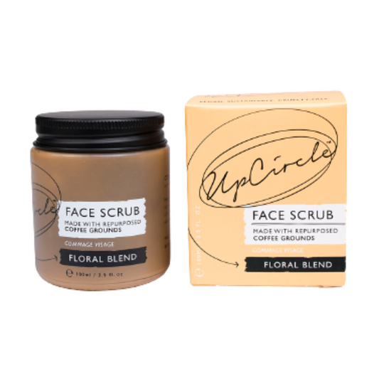 upcircle floral blend face scrub on a white backround. The face scrub jar is on the left which is orange glass and black aluminium lid and the peachy orange box is to the right. the white label reads 'face scrub made with repurposed coffee grounds floral blend'