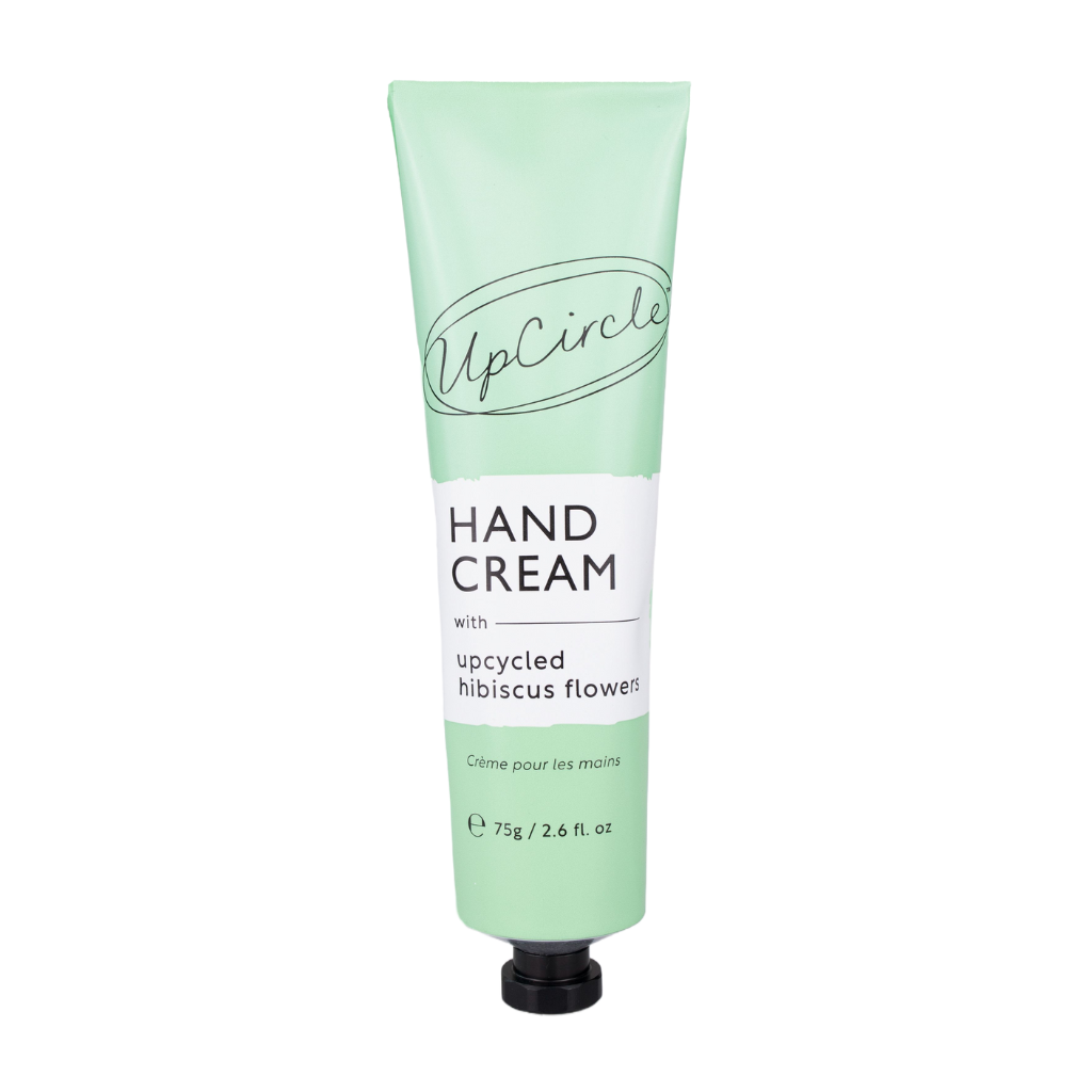 image of upcircle beauty's hand cream on a white background. the handcream comes in a sea green aluminium tube with a black plastic cap. the label reads 'upcircle hand cream with upcycled hibiscus flowers creme pour le mains 75g'