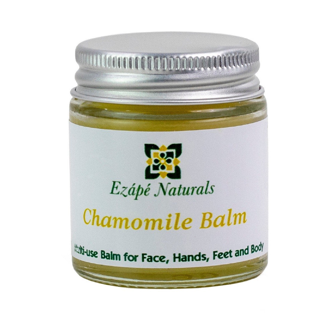 Small Chamomile balm which is handmade by ezape naturals is photographed on a white background. the multi use balm comes in a clear glass jar with a silver aluminium lid. the label is white and reads 'ezape naturals chamomile balm multi use balm for face, hands, feet and body’